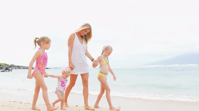 Mother walks with her daughters on the beach