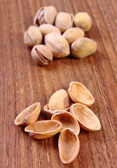 Pistachio nuts with shells on wooden table, healthy eating