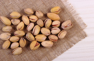 Pistachio nuts on white wooden table, healthy eating