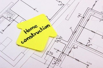 House of yellow paper with text home construction on construction drawing of house