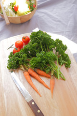 Obraz na płótnie Canvas parsley, carrot and tomato on chopping block