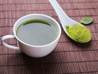 Matcha tea in a white cup on the mat