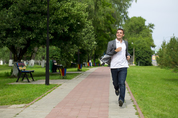 Casual young man walking in the summer park
