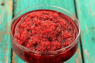 Obraz na płótnie Canvas Fresh homemade raspberry jam in glass jar on old turquoise table