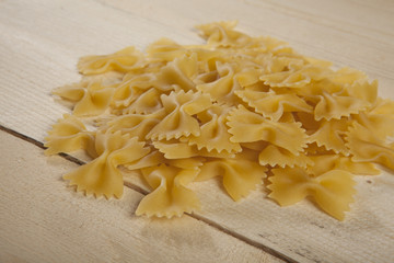 Farfalle di pasta su piano di legno chiaro