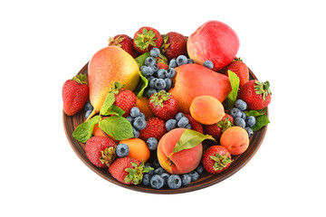 Fruits and berries mix in ceramic plate isolated on white