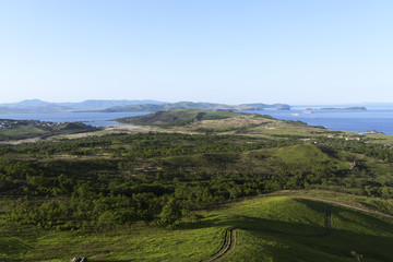 The blue sky, the sea and green hills