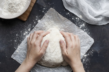 Hands knead the dough
