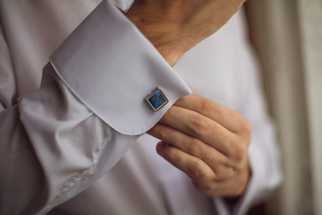 The man in the white shirt in the window dress cufflinks.