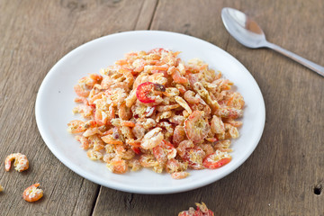 dried shrimp in white bowl on wooden table.