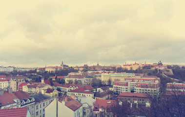 Fototapeta na wymiar Panoramic view on Prague, Czech Republic, from the top of Vysehrad fortress on a cloudy day. Image filtered in faded, washed out, retro style; nostalgic travel vintage concept.
