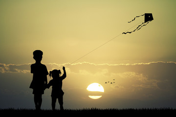 children with kite at sunset