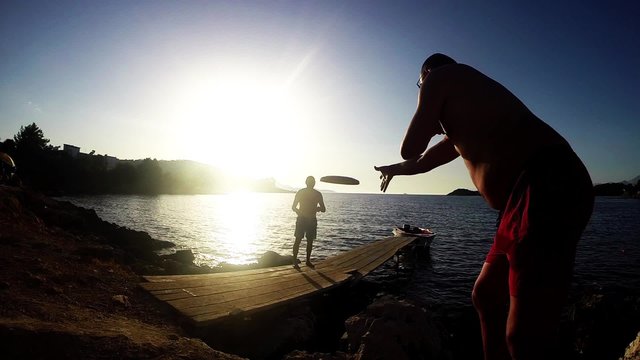 silhouette Playing Frisbee on sunset, slow motion