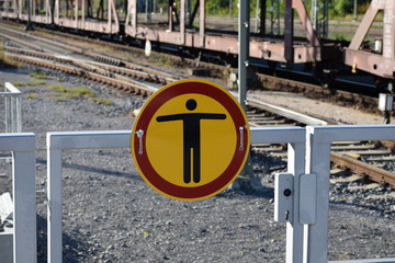 Schild und Lautsprecher auf dem Bahnsteig mit blauem Himmel und Stahlseilen