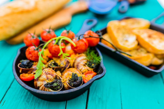 Baked escargot in butter with herbs and tomatoes