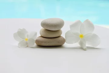 Foto op Canvas plumeria tropical flowers and pebbles  light white blue spa relaxation background, turquoise water, soft focus © Anna_ok