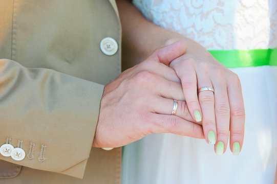 Hands of bride and groom with golden rings
