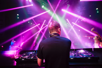 DJ with headphones at night club party - obrazy, fototapety, plakaty