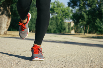 Fototapeta na wymiar Legs of a woman running on a dirt road