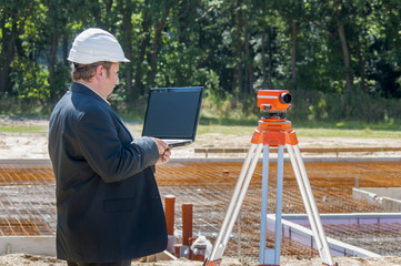 ingenieur mit laptop vor baugrube