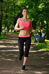 Beautiful woman runner running in city park