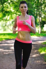 Fototapeta premium Beautiful woman runner running in city park