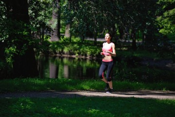 Beautiful woman runner running in city park