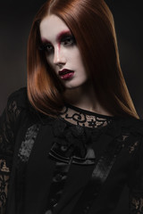 Portrait of gothic girl with black eyes in dark clothes