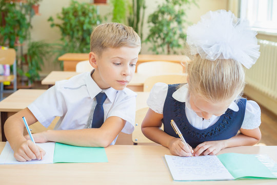 Students or classmates in school classroom sitting together at desk