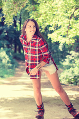 Roller skating girl in park rollerblading on inline skates