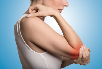 woman with painful elbow on blue background