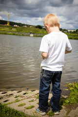 Lonely pensive child thinking by river. Solitude.