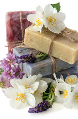 Obraz na płótnie Canvas Soap bars with fresh lavender, jasmine, clover and chamomile flo