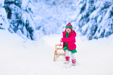 Fototapeta na wymiar Little girl having fun in snowy winter park