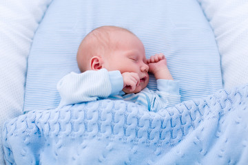 Newborn baby boy in white bassinet