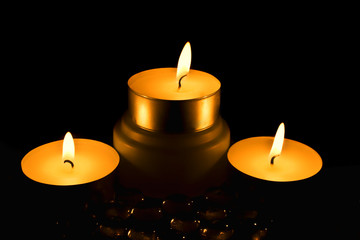 Three candles against a dark background