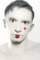 portrait of young brunette man with white skin and red heart on