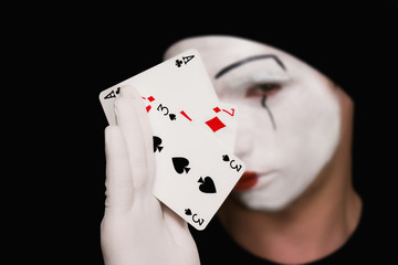 Portrait of  mime with playing cards on  black background