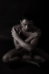 Fototapeta na wymiar handsome young naked man sitting on the floor