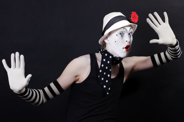 Funny mime in white hat with red flower