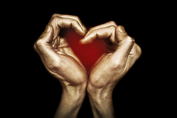 Male hands  in gold paint folded in the shape of a heart