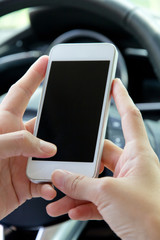 Young woman holding mobile device in the car