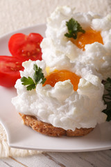 Beautiful toast with baked eggs Orsini on a plate close-up. vertical 
