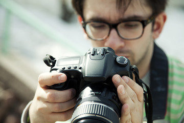 young man in spectacles with camera