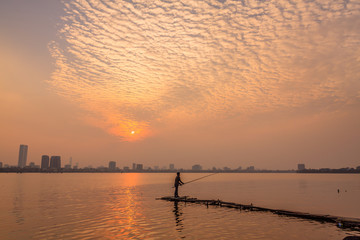 Fisher man on the west lake, hanoi, vietnam