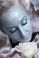 woman with silver make-up holding flower of white roses