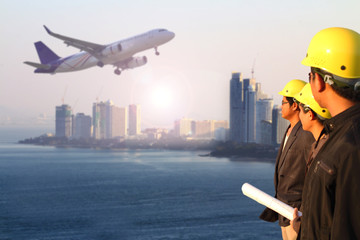 three engineer team standing in front of perspective view of jet airliner in flight with city background , use for air transport ,journey and travel industry business © sittinan