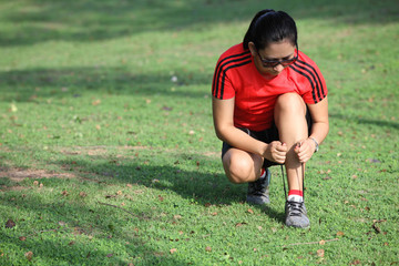 Running shoes - closeup of woman tying shoe laces. Female sport fitness runner getting ready for jogging outdoors on forest path in spring or summer.
