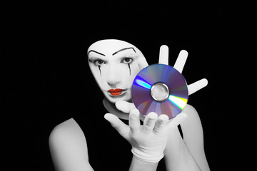 Portrait of  mime with cd on  black background