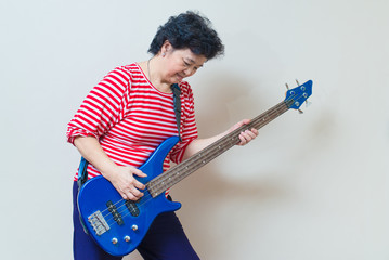Portrait of adult asian woman with electric bass, specialty tone
